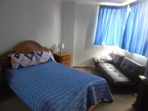 a bedroom with a bed and a couch in it at apartamento san martin in Quito