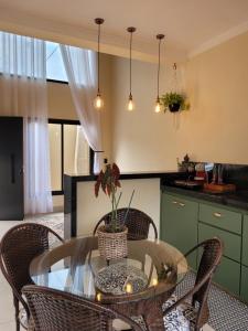 布罗塔斯BrotasLoft的厨房配有玻璃桌和一些椅子