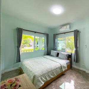 um quarto com uma cama e duas janelas em อิงแลนด์เฮ้าส์แอนด์พูล England8House&Pool em Khanom