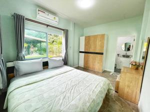 una camera con un grande letto e una finestra di อิงแลนด์เฮ้าส์แอนด์พูล England8House&Pool a Khanom