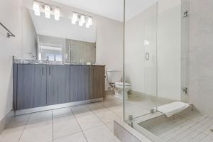 Modern Downtown Doral One-Bedroom Apt with Golf Course Views في ميامي: حمام مع دش ومغسلة ومرحاض