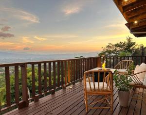 una terraza con mesa, sillas y el océano en Astonishing view at Poás Volcano slopes: Casa Lili, en Grecia