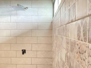 a bathroom with a shower with a tile wall at Astonishing view at Poás Volcano slopes: Casa Lili in Grecia