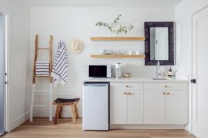 eine weiße Küche mit einer Spüle und einer Mikrowelle in der Unterkunft DUNE Fairfield Beach in Fairfield