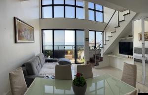 uma sala de estar com um sofá e uma mesa em Maravilhosa cobertura duplex vista mar em Salvador