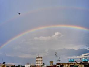 um arco-íris no céu sobre uma cidade em Chiangmai Inn Guest House em Chiang Mai