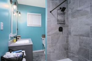 uma casa de banho com uma cabina de duche ao nível do chão ao lado de um lavatório em Buckeye Lake Cottage em Hebron