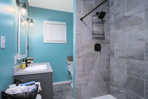 une salle de bain avec une douche à l'italienne à côté d'un lavabo dans l'établissement Buckeye Lake Cottage, à Hebron