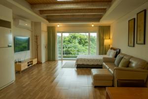 a large living room with a bed and a couch at Green Narae Pension in Seogwipo
