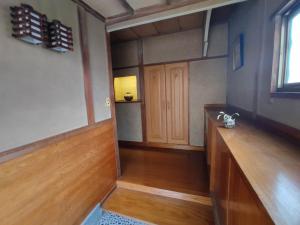 Guesthouse Kincha 駅東口 في أوتسونوميا: غرفه فارغه ارضيه خشبيه وباب خشبي