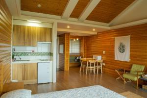 a kitchen and dining room with a table and chairs at Green Narae Pension in Seogwipo