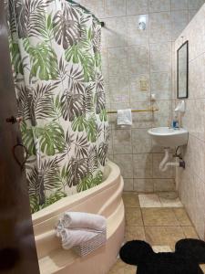 La salle de bains est pourvue d'un rideau de douche, d'une baignoire et d'un lavabo. dans l'établissement APARTAMENTO ESTUDIO - COMPLETO Y MUY BIEN UBICADO, à Baños