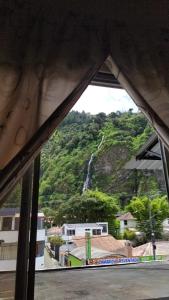 uma vista para uma cascata a partir de uma janela em APARTAMENTO ESTUDIO - COMPLETO Y MUY BIEN UBICADO em Baños