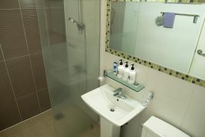 y baño con lavabo y ducha con espejo. en Green Narae Pension en Seogwipo