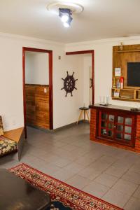 sala de estar con sofá y TV en Recanto da Árvore Suítes, en Arraial do Cabo