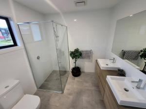 een badkamer met een douche, een toilet en een wastafel bij New 5 bedroom house in Rousehill in Riverstone