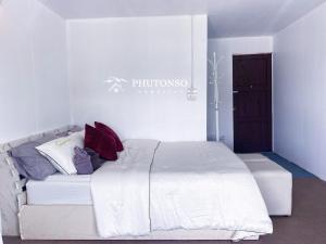 Un dormitorio con una cama blanca con almohadas. en Phutonso Homestay, en Chiang Mai
