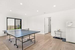 a ping pong table in a room with a refrigerator at Waikiki Beach House in Smiths Beach