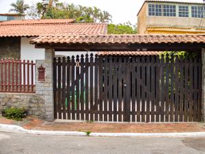 una puerta negra delante de una casa en Recanto da Árvore Suítes, en Arraial do Cabo