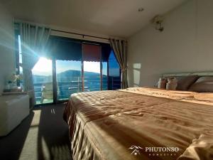 a bedroom with two beds and a large window at Phutonso Homestay in Chiang Mai
