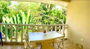 a table and chairs on a balcony with a window at Paradis Mimies Dominican Bay in Boca Chica +2 photos