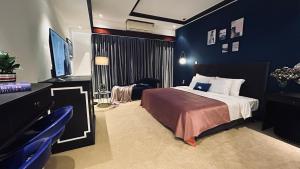 a hotel room with a bed and a television at Mango Hotel - Ha Noi Railway station in Hanoi