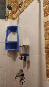 a bathroom with a blue paper towel dispenser on a wall at BAÑOS MINI DEPARTAMENTO AMOBLADO EN PLENO CENTRO de LA CIUDAD in Baños