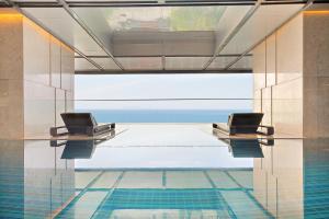 a lobby with two chairs and a pool at Grand Hyams Hotel - Quy Nhon Beach in Quy Nhon