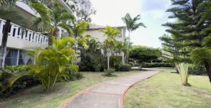 una pasarela frente a un edificio con palmeras en Paradis Mimies Apartment, en Boca Chica