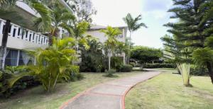 a walkway in front of a building with palm trees at Paradis Mimies Dominican Bay in Boca Chica