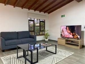 a living room with a couch and a tv at Palos Altos in Medellín