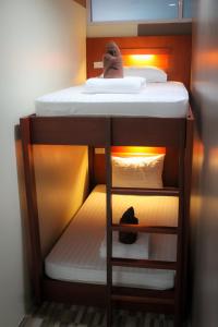 a small bedroom with a bunk bed with white sheets at Phangan Barsay Hostel in Thong Sala