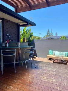 un patio con tavolo, sedie e panca di Room in a Family home a Gold Coast