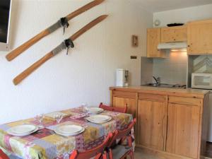 a kitchen with a table with plates and wine glasses on it at Appartement Vars, 1 pièce, 4 personnes - FR-1-330B-211 in Vars