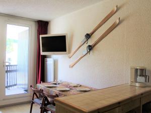 a dining room with a table and a tv on the wall at Appartement Vars, 1 pièce, 4 personnes - FR-1-330B-211 in Vars