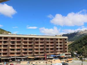 ein großes Apartmenthaus mit Bergen im Hintergrund in der Unterkunft Studio cosy avec balcon, 4 couchages à Vars, proche pistes et commerces - FR-1-330B-211 in Vars