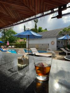 uma bebida sentada numa mesa ao lado de uma piscina em Adarin Beach Resort em Mae Nam