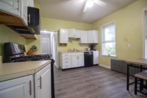 a kitchen with yellow walls and white cabinets at 2 bedroom condo close to Boston and Cambridge with free parkings in Boston