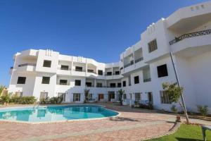 un gran edificio blanco con una piscina frente a él en La bonita compound, en Hurghada