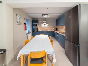 a kitchen with a table with yellow chairs and blue cabinets at Luxury Family Holiday Home With Wellness in Binsfeld