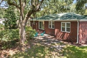 dom z czerwonej cegły z drzewem w ogrodzie w obiekcie The Oak House w mieście Charleston