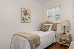 um quarto branco com uma cama e uma janela em The Oak House em Charleston