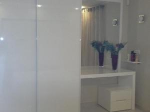 a bathroom with a glass shower with a shelf and flowers at Holiday Home Irina in Utjeha