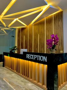 a reception desk in a lobby with flowers on it at Sinergi Hotel & Villa in Sengkaling