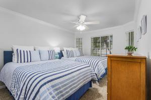 a bedroom with two beds and a ceiling fan at Sunshine Daydream our Beautiful Monthly Pool Home! home in Fort Myers