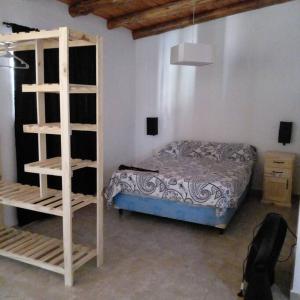 a bedroom with a bed and a book shelf at Monoambiente amplio con pileta in Cosquín