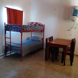 a bedroom with a bunk bed and a wooden table at Monoambiente amplio con pileta in Cosquín