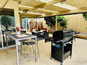 a patio with a grill and a table and chairs at Ocean Breeze Family Getaway - Short drive to Beach & Adventure Park in Ocean Grove