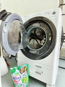 a washing machine with its door open next to a container at ホステル今鶴 二人部屋 302号室 in Osaka
