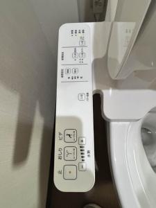 a control panel for a toilet in a bathroom at ホステル今鶴 二人部屋 302号室 in Osaka